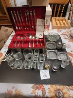 Full view of all items in the lot including Tudor Plate silverware in case, drinking glasses, ashtrays, and glass dish with salt and pepper shakers.