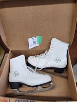 Pair of white ladies ice skates in size 8 inside a box, showing overall condition and style.