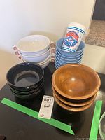 Photo showing four stacked sets of bowls in white, light blue, black, and wooden material, plus vintage Blue Jays plastic cup.
