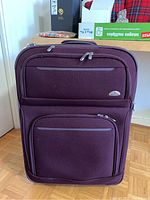 Front view of the burgundy Samsonite luggage with multiple zipped compartments visible.