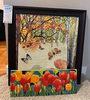 Three stacked artworks: framed forest print, botanical bird print, ceramic tulip tile