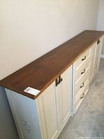 Left angled view showing painted off-white cabinet body and dark stained top