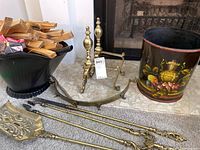 Shows coal bucket, decorative waste basket, brass andirons, and brass fender near fireplace, with a tag visible on fender.