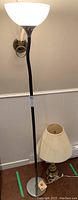 Full view of the tall floor lamp with adjustable neck next to small table lamp with pleated fabric shade.