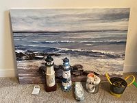 Full view of seascape canvas print with marine decorative items in front.