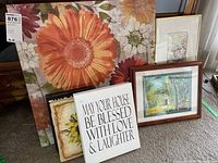 Six pieces of wall art arranged grouped including large floral canvas, inspirational quote sign, framed landscape and floral prints, and unframed sunflower prints