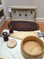 Full view of wooden serving ware set including bowl, tray, boards, spice grinders, coaster and wall decor