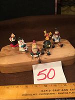 Five winter holiday figurine bottle stoppers on wooden base showing overall lot