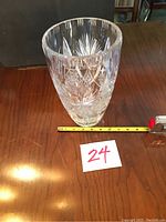 Front angled view of the heavy crystal vase showing the cut starburst design with measuring tape indicating height.