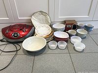 Wide view of Curtis boombox, vintage plates, bowls, cups, and soft pouch.