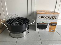Crock-Pot Classic slow cooker box and stove top fryer pot with wire rack and silver base.