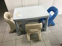 Full set showing rectangular kids outdoor table and four plastic chairs on tiled floor.