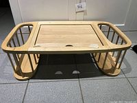 Front view of the wooden breakfast tray showing adjustable tray surface and side compartments