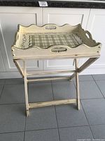 Full view of the assembled butler tray and stand, showing the off-white distress finish and tray shape with handles.