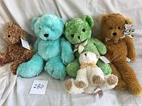 Front view of the 5 stuffed animals arranged sitting upright with tags visible.