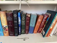 Books on shelf showing various bibles such as Parallel Bible, Living Bible, Holy Bible NKJV, Chronological Life Application Study Bible