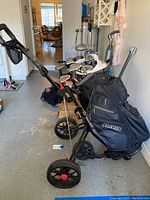 Photo showing golf bag full of Wilson Tour Model II clubs mounted on a RAM push cart with three wheels.