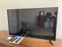 Front view of the Samsung 44 inch TV with two remotes placed on the table in front of it.