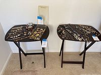 Two wood folding TV tray tables with dark wood tops and black folding legs, jewelry displayed on tops is not included.