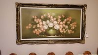 Full frontal view of the framed floral painting showing pink roses in a green vase under an ornate gold-tone frame