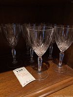 Eight Preludio stemmed crystal goblets arranged on a wooden shelf, showing clear cut crystal design and faceted stems.