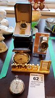 Overview of all timepieces: Seiko watch in box, unbranded watch in packaging, Coachman clock, MOM desk clock, stopwatch