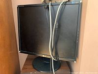 Front view of the LG 19-inch LCD monitor with attached cables, black bezel and stand.