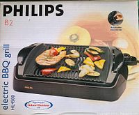 Front of the boxed Philips HL4500 electric BBQ grill showing product image, brand, and key features like adjustable thermostat and indoor/outdoor approval.
