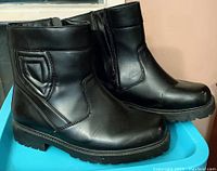 Side view of men's black winter boots showing outside zipper and padded ankle detail.