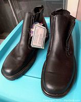 Front view of both black leather men's winter boots, showing smooth leather and zipper on inner side.
