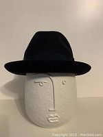 Front view of black fedora on display head