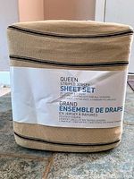 Photo of the folded, packaged queen size striped jersey sheet set with label showing product details and design.