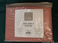 Front view of packaged sheet set showing brand, size, thread count and color through plastic wrap