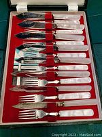 Set of 16 silver plated fish utensils displayed in red lined fitted case.