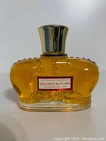 Front view of the sealed Prince Matchabelli Golden Autumn cologne bottle, showing the red and white label and shape of bottle with amber liquid inside