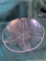 Top view showing clear glass platter with detailed embossed leaf pattern in a large size