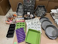 Full lot view showing all assorted holiday-themed bakeware on table including pans and silicone molds