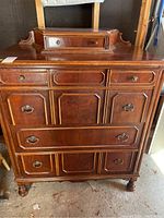 Front view of the highboy dresser showing four main drawers and decorative hardware.