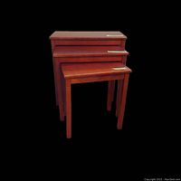 Three wood rectangular nesting tables arranged front to back by size.