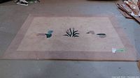 Full view of the rectangular rug laid flat on the floor showing wear and dirt.