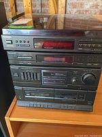 Photo of Panasonic stereo system components stacked on wooden surface including CD player, cassette player, and amplifier units.