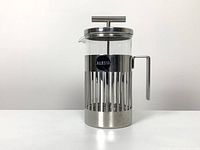 Front view of glass carafe in stainless steel base with handle and lid