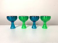 Front view showing the set of four Alessi Big Love ice cream bowls in alternating blue and green thermoplastic with stainless steel inserts.