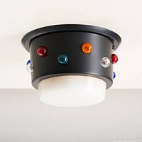 Full view of the black cylindrical ceiling fixture mounted with colorful glass accent domes around its perimeter and a white milk glass diffuser at the bottom.