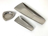 Top-down view of three stainless steel serving pieces: one large tray, one smaller tray, and one round dish with notch