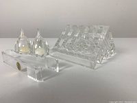 Overall display of all four Guzzini lucite items on white background, includes pen holder, salt & pepper shakers, and tongs.