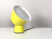 Lamp on surface, side-view showing angled shade and base profile