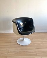 Front-left angle of chair showing seat shape and pedestal base