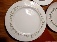 Close-up of one Sheffield Fine China Elegance plate showing green floral vine pattern around rim.