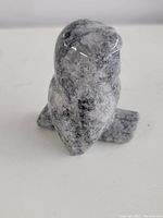 Front angle of the hand carved stone owl figurine showing the polished surface and speckled color pattern.